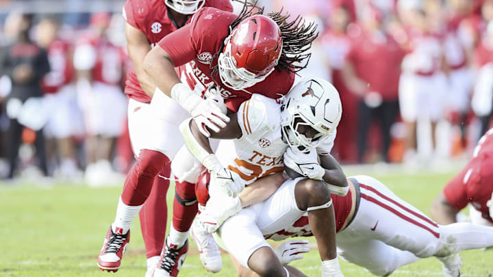 Texas Longhorns running back Quintrevion Wisner (26) is tackled in the fourth quarter by Arkansas Razorbacks defensive lineman Keivie Rose (93) at Donald W. Reynolds Razorback Stadium. Texas won 20-10. Mandatory Credit: Nelson Chenault-Imagn Images