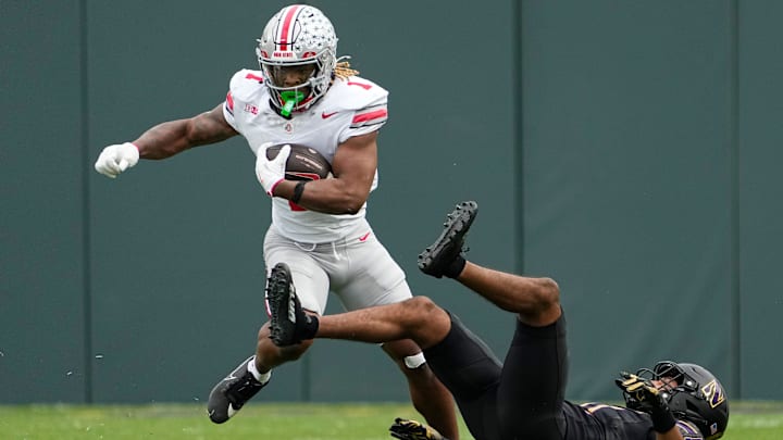 Ohio State Buckeyes running back Quinshon Judkins (1) runs over Northwestern Wildcats defensive back Damon Walters (21) during the NCAA football game at Wrigley Field in Chicago on Monday, Nov. 18, 2024. Ohio State won 31-7.