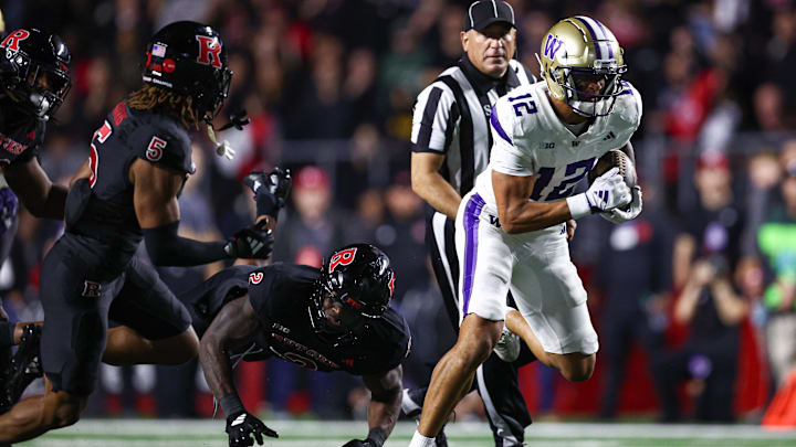 Sep 27, 2024; Piscataway, New Jersey, USA; Washington Huskies wide receiver Denzel Boston (12) breaks a tackle by Rutgers Scarlet Knights linebacker Moses Walker (2) for a touchdown during the second half at SHI Stadium. Mandatory Credit: Vincent Carchietta-Imagn Images