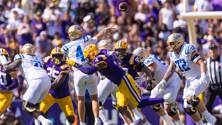 Sep 21, 2024; Baton Rouge, Louisiana, USA;  UCLA Bruins quarterback Ethan Garbers (4) releases the ball before being hit by LSU Tigers defensive end Bradyn Swinson (4) during the first half at Tiger Stadium. Mandatory Credit: Stephen Lew-Imagn Images