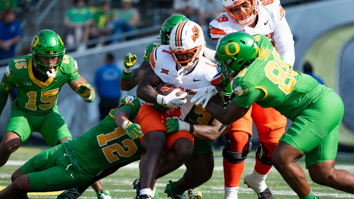 Oklahoma State running back Kalib Hicks is brought down by a pack of Oregon defenders as the Oregon Ducks host the Oklahoma State Cowboys on Sept. 6, 2025, at Autzen Stadium in Eugene, Oregon.