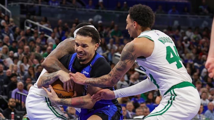 Apr 9, 2025; Orlando, Florida, USA; Orlando Magic guard Cole Anthony (50), Boston Celtics forward Miles Norris (44) and forward Torrey Craig (12) battle for the ball during the second half at Kia Center. Mandatory Credit: Mike Watters-Imagn Images