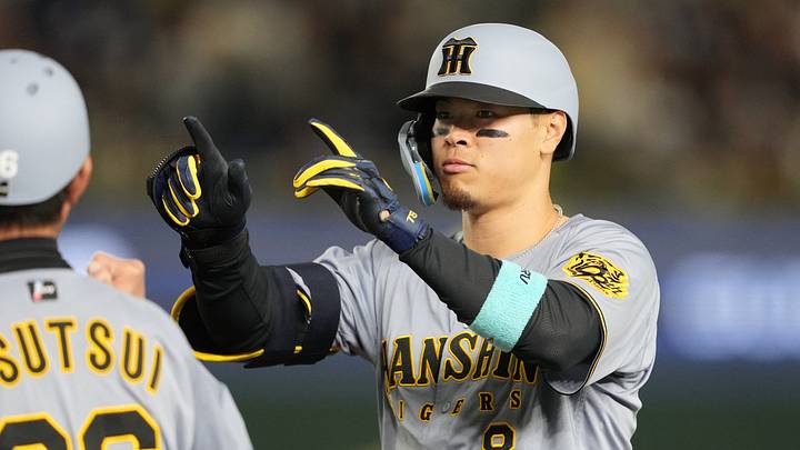 Mar 15, 2025; Bunkyo, Tokyo, Japan; Hanshin Tigers right fielder Teruaki Sato (8) gestures after hitting an RBI-single against the Chicago Cubs during the fifth inning at Tokyo Dome. Mandatory Credit: Darren Yamashita-Imagn Images