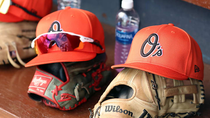 Mar 11, 2024; Tampa, Florida, USA; A detailed view of Baltimore Orioles baseball hats and gloves in the dugout during the first inning against the New York Yankees at George M. Steinbrenner Field. Mandatory Credit: Kim Klement Neitzel-Imagn Images Mar 11, 2024; Tampa, Florida, USA; A detailed view of Baltimore Orioles baseball hats and gloves in the dugout during the first inning against the New York Yankees at George M. Steinbrenner Field. Mandatory Credit: Kim Klement Neitzel-Imagn Images
