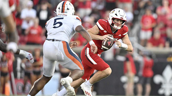 Oct 4, 2025; Louisville, Kentucky, USA; Louisville Cardinals quarterback Miller Moss (7) scrambles under the pressure of Virginia Cavaliers linebacker Kam Robinson (5) during the second half at L&N Federal Credit Union Stadium. Virginia defeated Louisville 30-27. Mandatory Credit: Jamie Rhodes-Imagn Images