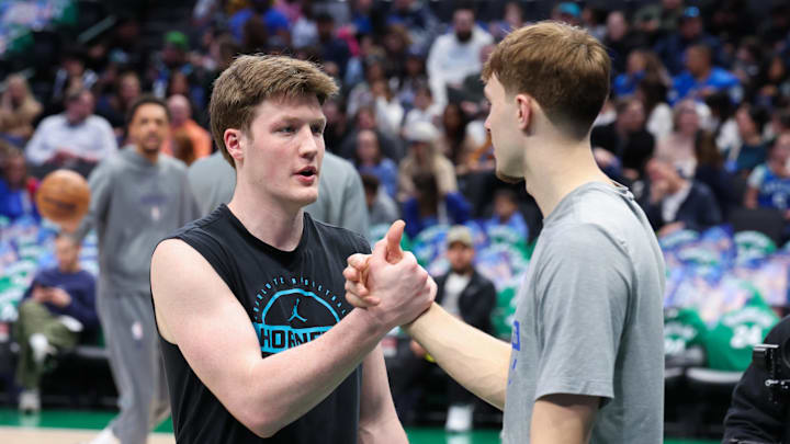 Dallas Mavericks forward Cooper Flagg (right) speaks with Charlotte Hornets guard Kon Knueppel 