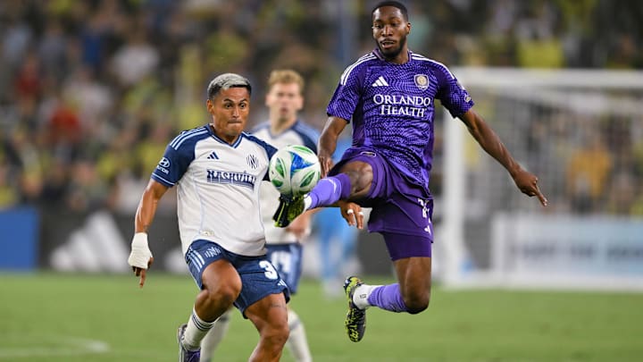 Aug 23, 2025; Nashville, Tennessee, USA;  Orlando City forward Tyrese Spicer (14) steals the ball from Nashville SC midfielder Andy Najar (31) during the first half at Geodis Park. Mandatory Credit: Steve Roberts-Imagn Images