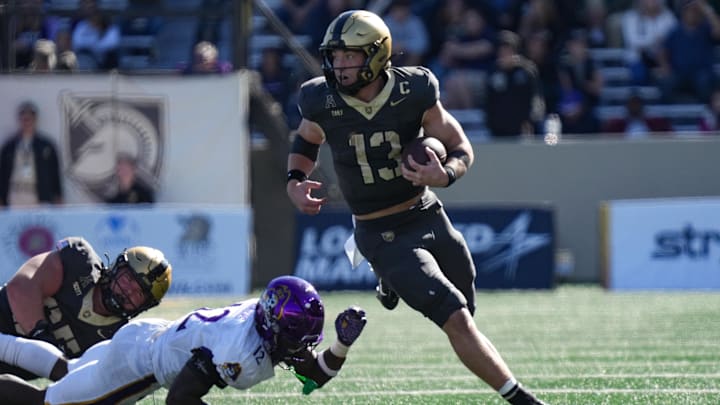 Oct 19, 2024; West Point, New York, USA; Army Black Knights quarterback Bryson Daily (13) evades a tackle from East Carolina Pirates defensive back Omar Rogers (12) during the second half at Michie Stadium. Mandatory Credit: Lucas Boland-Imagn Images