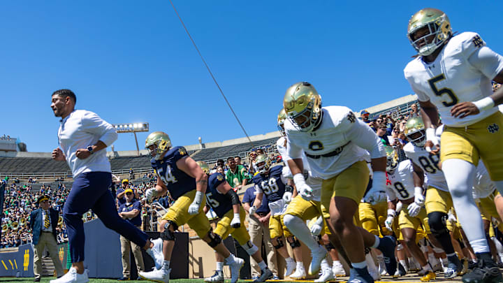 Apr 25, 2026; Notre Dame, IN, USA; Notre Dame Fighting Irish head coach Marcus Freeman runs out with the team before the Blue-Gold game at Notre Dame Stadium. Mandatory Credit: Michael Caterina-Imagn Images