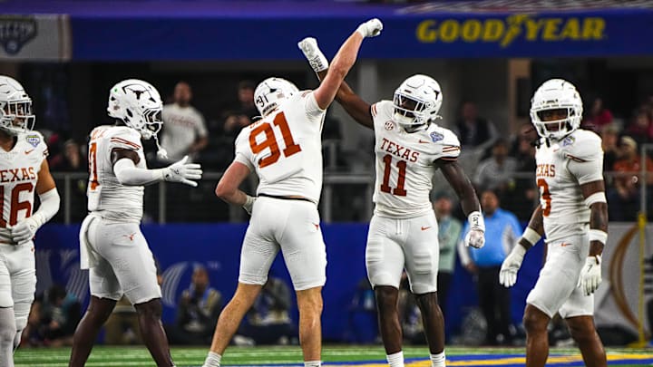 Texas Longhorns edge rushers Colin Simmons (11) and Ethan Burke (91) celebrate a sack during the College Football Playoff semifinal game against Ohio State in the Cotton Bowl at AT&T Stadium on Friday, Jan. 10, 2024 in Arlington, Texas.