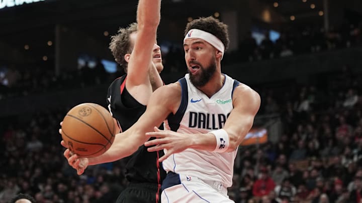 Dec 7, 2024; Toronto, Ontario, CAN; Dallas Mavericks guard Klay Thompson (31) passes the ball against Toronto Raptors center Jakob Poeltl (19) during the second quarter at Scotiabank Arena. Mandatory Credit: Nick Turchiaro-Imagn Images