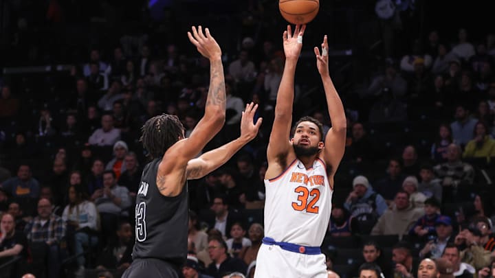 Jan 21, 2025; Brooklyn, New York, USA;  New York Knicks center Karl-Anthony Towns (32) takes a three-point shot past Brooklyn Nets center Nic Claxton (33) in the first quarter at Barclays Center. Mandatory Credit: Wendell Cruz-Imagn Images