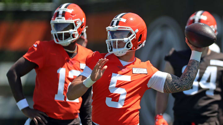 Cleveland Browns quarterback Dillon Gabriel (5) throws as quarterback Shedeur Sanders (12) looks on during NFL rookie minicamp at the Cleveland Browns training facility.