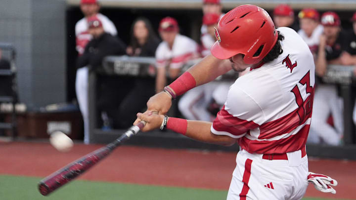 Louisville's Tague Davis (13) hits the ball to the fence for the out but enough time for Louisville's Jake Munroe (20) to tag up and head home against Vanderbilt Tuesday night at Jim Patterson Stadium.
May 6, 2025