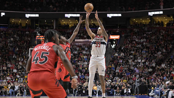 Oct 6, 2024; Montreal, Quebec, CAN; Washington Wizards small forward Kyle Kuzma (33) takes a jump shot and Toronto Raptors shooting guard RJ Barrett (9) defends during the first quarter at the Bell Centre. Mandatory Credit: Eric Bolte-Imagn Images