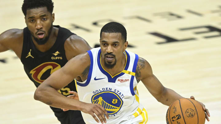 Golden State Warriors guard De'Anthony Melton drives past Cleveland Cavaliers guard Donovan Mitchell.