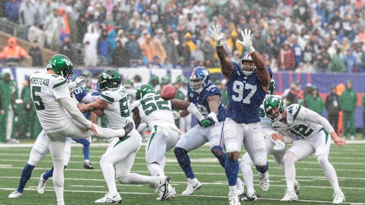 Oct 29, 2023; East Rutherford, New Jersey, USA; New York Jets punter Thomas Morstead (5) punts the ball as New York Giants defensive tackle Dexter Lawrence II (97) defends during the second half at MetLife Stadium. Mandatory Credit: Vincent Carchietta-Imagn Images