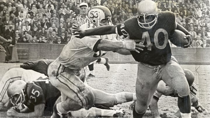 Donnie Moore runs through an Ohio State tackle in 1965 at Husky Stadium. Donnie Moore runs through an Ohio State tackle in 1965 at Husky Stadium.