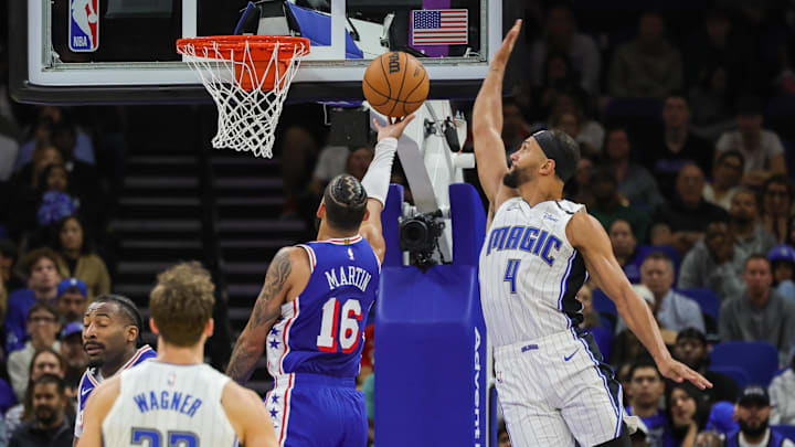 Orlando Magic guard Jalen Suggs (4) blocks a shot by Philadelphia 76ers forward Caleb Martin (16) during the second half at Kia Center.