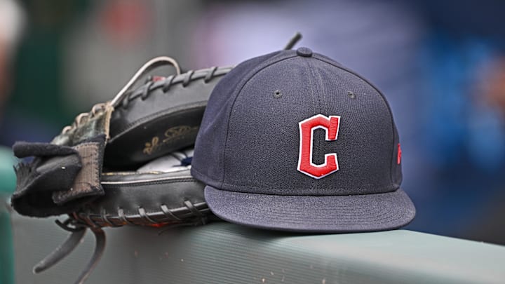 Jun 27, 2024; Kansas City, Missouri, USA; A general view a Cleveland Guardians hat and glove on the dugout railing  before a game against the Kansas City Royals at Kauffman Stadium. Mandatory Credit: Peter Aiken-Imagn Images
