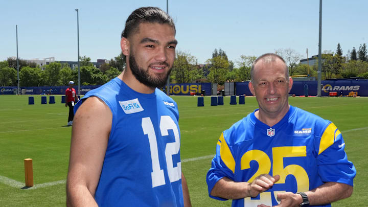 May 7, 2025; Woodland Hills, CA, USA; Los Angeles Rams receiver Puka Nacua (left) talks with Hawaii governor Josh Green, M.D. after a press conference at the Rams Practice Facility to announce a partnership between the Rams and the Hawaii Tourism Authority to hold minicamp in Maui. Mandatory Credit: Kirby Lee-Imagn Images