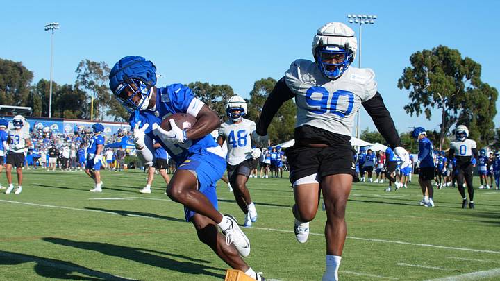 Jul 23, 2025; Los Angeles, CA, USA; Los Angeles Rams receiver Xavier Smith (19) carries the ball against defensive end Tyler Davis (90) during training camp at Loyola Marymount University. Mandatory Credit: Kirby Lee-Imagn Images