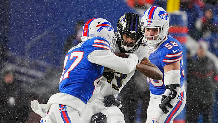Baltimore Ravens running back Justice Hill gets taken down by Buffalo Bills cornerback Christian Benford, linebacker Terrel Bernard and linebacker Matt Milano during first half action at the Buffalo Bills divisional game against the Baltimore Ravens at Highmark Stadium in Orchard Park on Jan. 19, 2025.