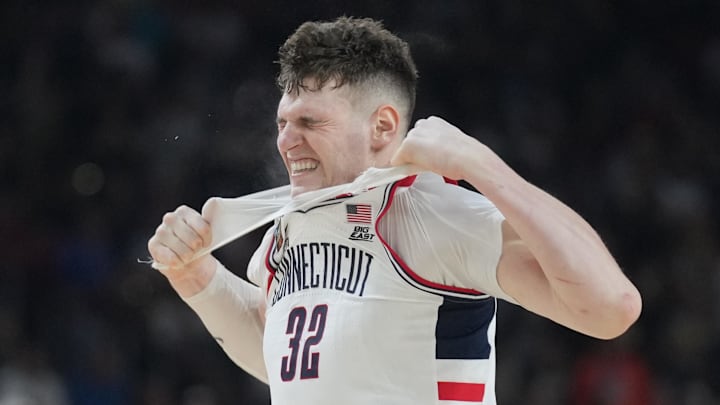 Apr 8, 2024; Glendale, AZ, USA; Connecticut Huskies center Donovan Clingan (32) reacts and rips his undershirt in the second half against the Purdue Boilermakers in the national championship game of the Final Four of the 2024 NCAA Tournament at State Farm Stadium. Mandatory Credit: Robert Deutsch-USA TODAY Sports