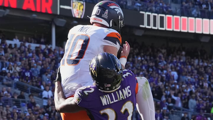 Denver Broncos quarterback Bo Nix (10) leaps to catch a second quarter touchdown defended by Baltimore Ravens safety Marcus Williams (32) at M&T Bank Stadium.