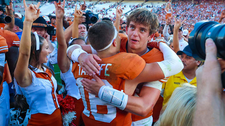 Texas Longhorns quarterback Arch Manning hugs Texas Longhorns defensive back Michael Taaffe after the game against the Oklahoma Sooners
