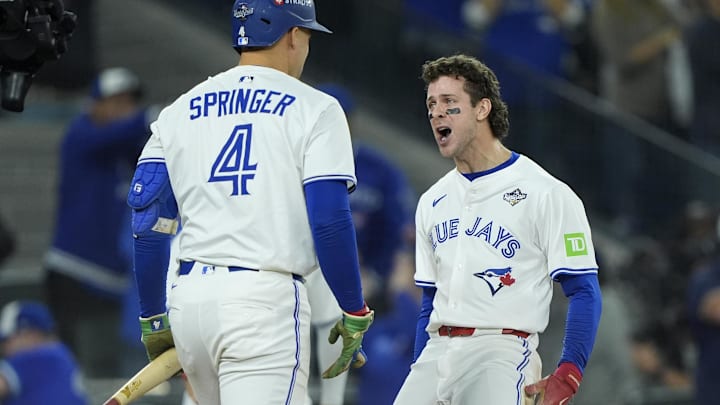 Nov 1, 2025; Toronto, Ontario, CAN; Toronto Blue Jays third baseman Ernie Clement (22) celebrates with right fielder George Springer (4) after scoring in the sixth inning during game seven of the 2025 MLB World Series at Rogers Centre 