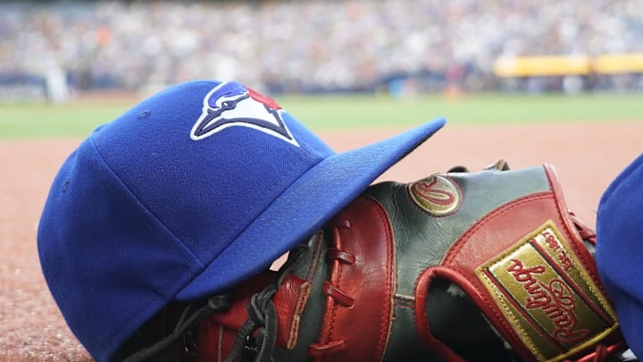Jul 26, 2024; Toronto, Ontario, CAN; A Toronto Blue Jays hat and glove outside of the dugout during a game against the Texas Rangers at Rogers Centre. Mandatory Credit: John E. Sokolowski-Imagn Images