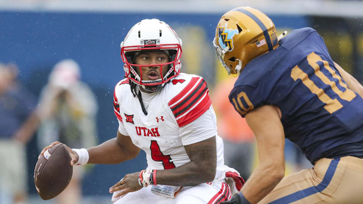 Utah Utes quarterback Devon Dampier (4) looks to pass while being pressured by West Virginia Mountaineers linebacker Braden Siders (10) during the first quarter at Milan Puskar Stadium.