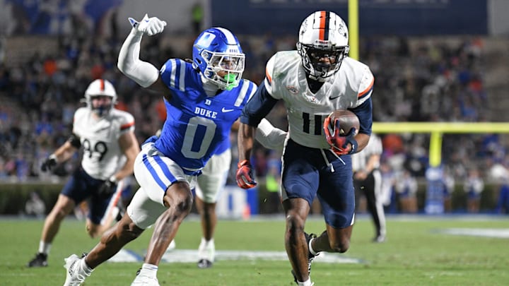 Nov 15, 2025; Durham, North Carolina, USA;  Duke Blue Devils cornerback Chandler Rivers (0) attempts to swat the ball from Virginia Cavaliers wide receiver Trell Harris (11) during the third quarter at Wallace Wade Stadium. Mandatory Credit: Zachary Taft-Imagn Images