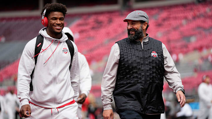 Ohio State Buckeyes safety Caleb Downs and defensive coordinator Matt Patricia walk across the field as the team arrives prior to the NCAA football game against the Grambling State Tigers at Ohio Stadium on Sept. 6, 2025.