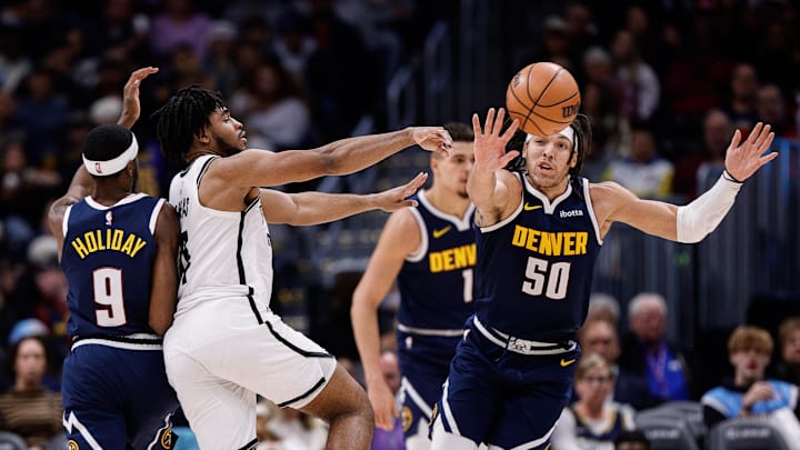 Dec 14, 2023; Denver, Colorado, USA; Brooklyn Nets guard Cam Thomas (24) passes the ball under pressure from Denver Nuggets forward Justin Holiday (9) and forward Aaron Gordon (50) in the third quarter at Ball Arena. Mandatory Credit: Isaiah J. Downing-Imagn Images
