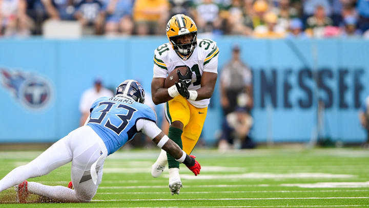 Sep 22, 2024; Nashville, Tennessee, USA;  Tennessee Titans safety Jamal Adams (33) tackles Green Bay Packers running back Emanuel Wilson (31) during the first half at Nissan Stadium. Mandatory Credit: Steve Roberts-Imagn Images