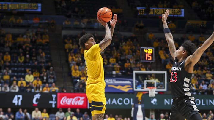 Feb 19, 2025; Morgantown, West Virginia, USA; West Virginia Mountaineers guard Jonathan Powell (11) shoots a three point shot over Cincinnati Bearcats forward Dillon Mitchell (23) during the second half at WVU Coliseum. Mandatory Credit: Ben Queen-Imagn Images Feb 19, 2025; Morgantown, West Virginia, USA; West Virginia Mountaineers guard Jonathan Powell (11) shoots a three point shot over Cincinnati Bearcats forward Dillon Mitchell (23) during the second half at WVU Coliseum. Mandatory Credit: Ben Queen-Imagn Images
