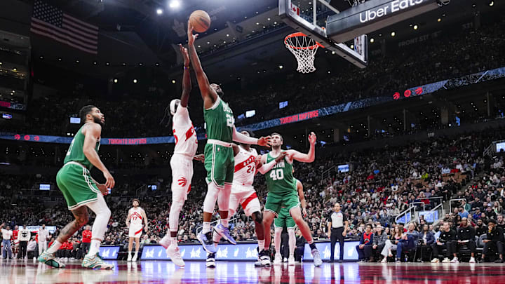 Oct 15, 2024; Toronto, Ontario, CAN; Boston Celtics forward Xavier Tillman (26) battles for the rebound against Toronto Raptors forward Chris Boucher (25) during the second half at Scotiabank Arena. Mandatory Credit: Kevin Sousa-Imagn Images