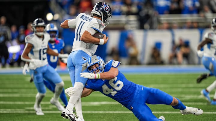 Tennessee Titans quarterback Mason Rudolph (11) tries to avoid being sacked by Detroit Lions linebacker Jack Campbell (46) during the first half of the NFL game at Ford Field in Detroit on Oct. 27, 2024.