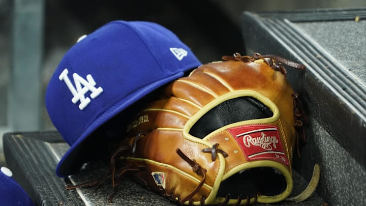 Apr 28, 2024; Toronto, Ontario, CAN; A hat and glove of an Los Angeles Dodgers player durng a game against the Toronto Blue Jays at Rogers Centre. Mandatory Credit: John E. Sokolowski-Imagn Images