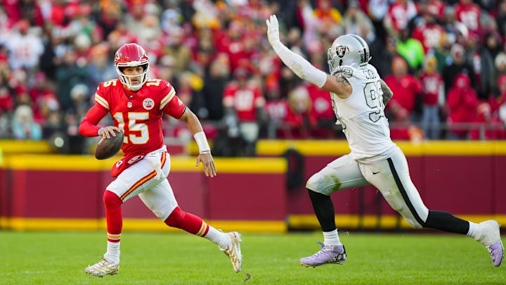 Nov 29, 2024; Kansas City, Missouri, USA; Kansas City Chiefs quarterback Patrick Mahomes (15) scrambles against Las Vegas Raiders defensive end Maxx Crosby (98) during the first half at GEHA Field at Arrowhead Stadium. Mandatory Credit: Jay Biggerstaff-Imagn Images