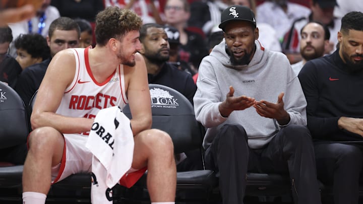 Oct 6, 2025; Houston, Texas, USA; Houston Rockets forward Kevin Durant (right) talks with center Alperen Sengun (28) on the bench during the second quarter against the Atlanta Hawks at Toyota Center. Mandatory Credit: Troy Taormina-Imagn Images