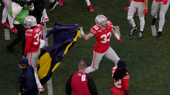 Ohio State Buckeyes defensive end Jack Sawyer (33) throws a Michigan flag taken from opposing players at midfield following last Saturday's game. 