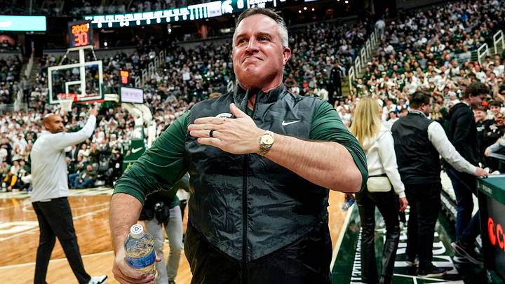 Michigan State's new football coach Pat Fitzgerald pats his heart at the crowd in attendance for the Spartans basketball game against Iowa on Tuesday, Dec. 2, 2025, at the Breslin Center in East Lansing. Michigan State's new football coach Pat Fitzgerald pats his heart at the crowd in attendance for the Spartans basketball game against Iowa on Tuesday, Dec. 2, 2025, at the Breslin Center in East Lansing.
