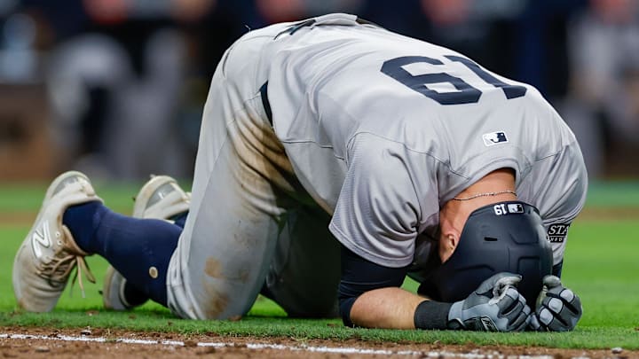 May 24, 2024; San Diego, California, USA; New York Yankees third baseman Jon Berti (19) collapses while running down to first base after sustaining an injury in the ninth inning against the San Diego Padres at Petco Park. 