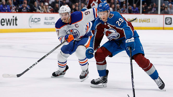 Feb 19, 2023; Denver, Colorado, USA; Colorado Avalanche center Nathan MacKinnon (29) controls the puck ahead of Edmonton Oilers center Connor McDavid (97) in overtime at Ball Arena. Mandatory Credit: Isaiah J. Downing-Imagn Images