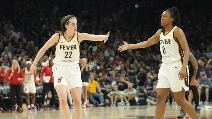 Jun 30, 2024; Phoenix, Ariz., U.S.; Indiana Fever guard Caitlin Clark (22) slaps hands with guard Kelsey Mitchell (0) during the third quarter against the Phoenix Mercury at Footprint Center. Mandatory Credit: Michael Chow-Arizona Republic