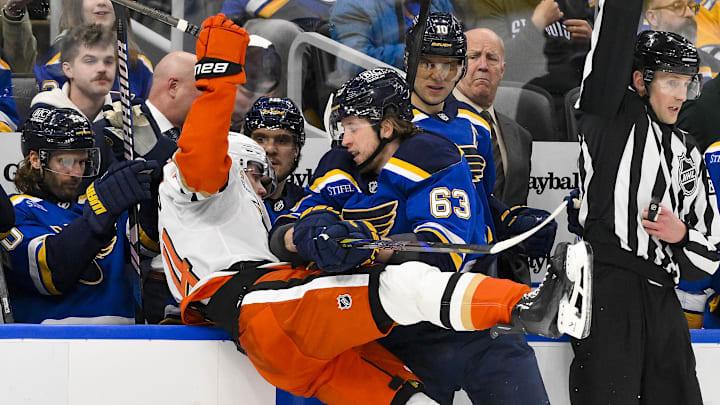 Jan 9, 2025; St. Louis, Missouri, USA;  St. Louis Blues left wing Jake Neighbours (63) checks Anaheim Ducks defenseman Pavel Mintyukov (34) during the second period at Enterprise Center. Mandatory Credit: Jeff Curry-Imagn Images