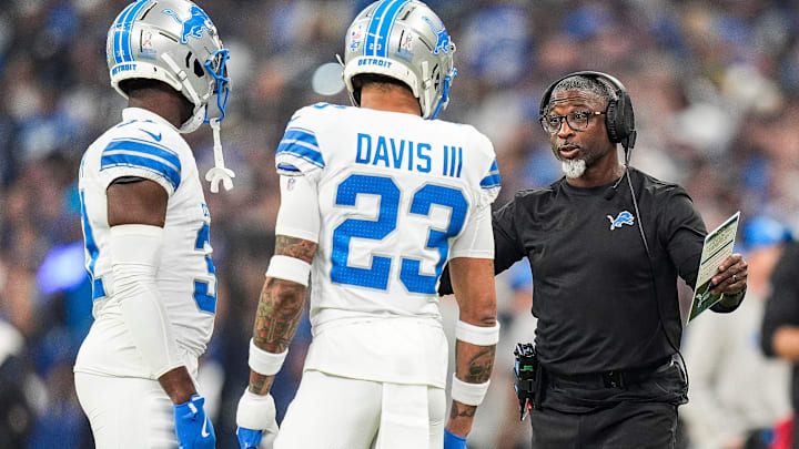 Detroit Lions defensive coordinator Aaron Glenn, right, talks to cornerback Carlton Davis III (23) 